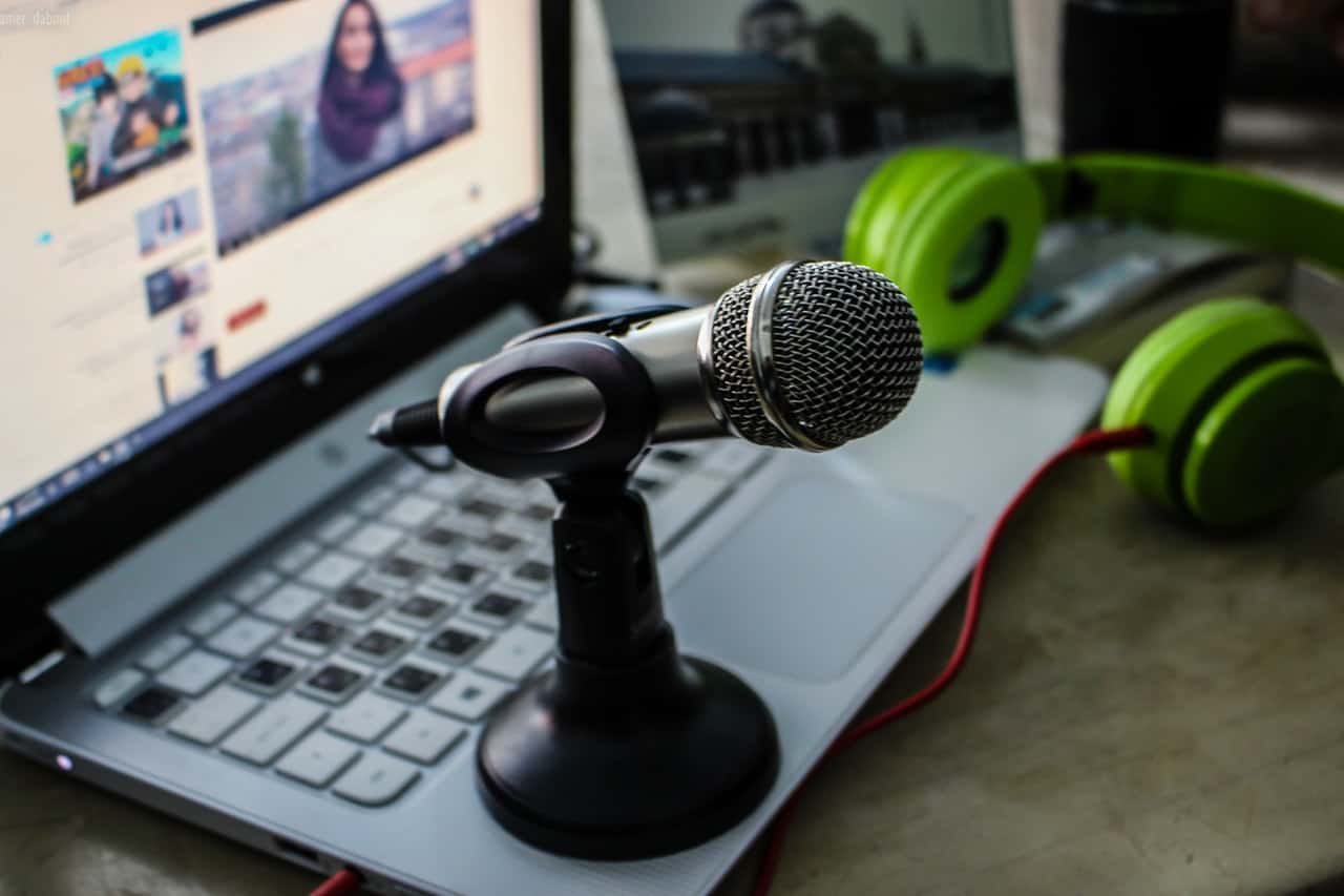 microphone sitting on laptop next to green headphones