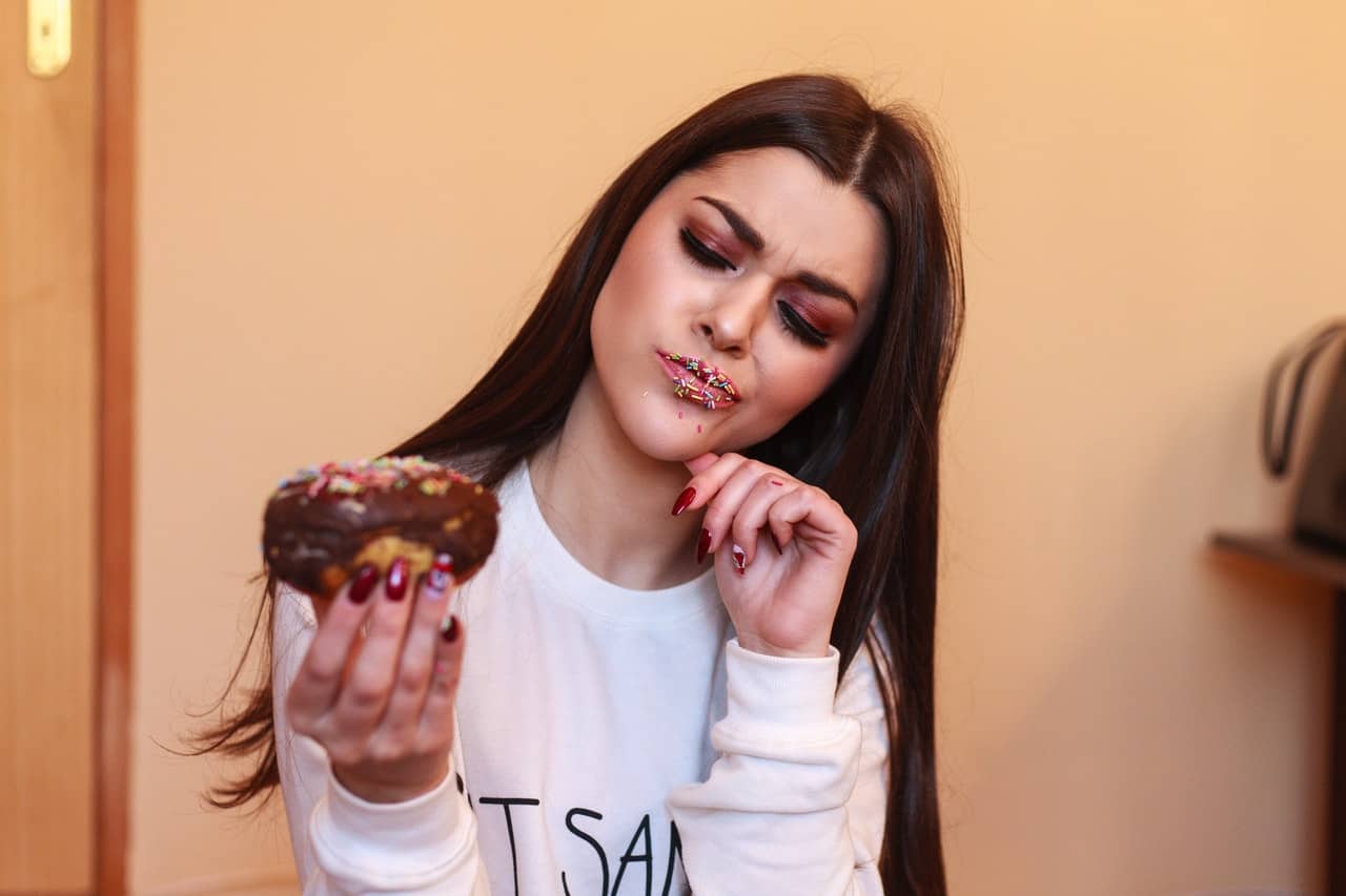 Woman questioning a donut's freshness